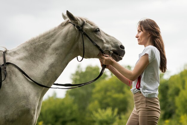 Mujer paseando con un caballo en el campo