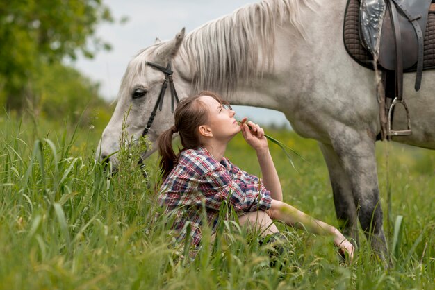 Mujer paseando con un caballo en el campo