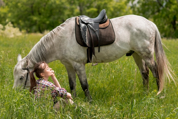 Mujer paseando con un caballo en el campo