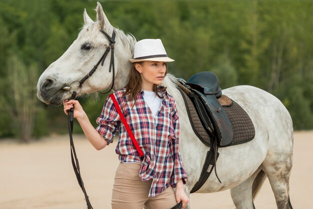 Mujer paseando con un caballo en el campo