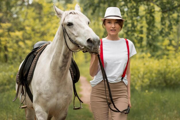 Mujer paseando con un caballo en el campo