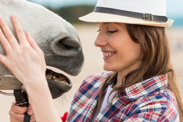 Mujer paseando con un caballo en el campo