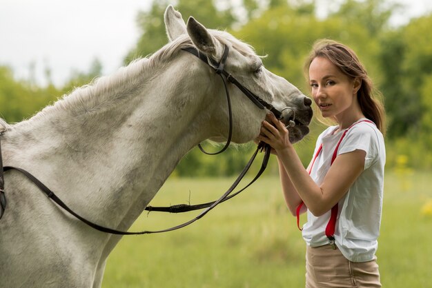 Mujer paseando con un caballo en el campo