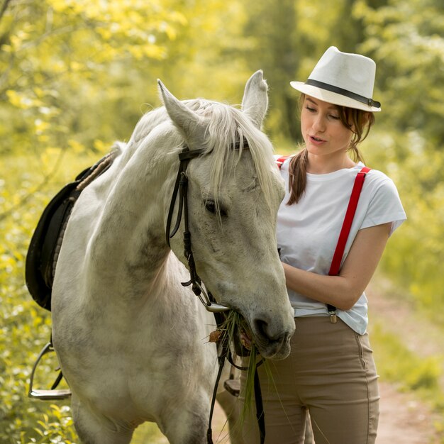 Mujer paseando con un caballo en el campo