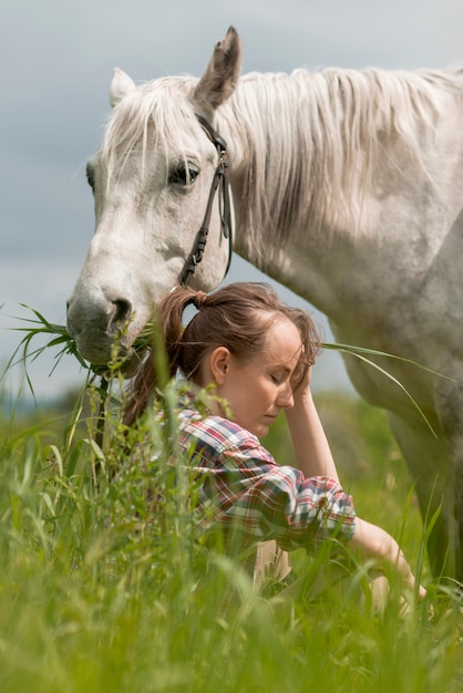 Mujer paseando con un caballo en el campo