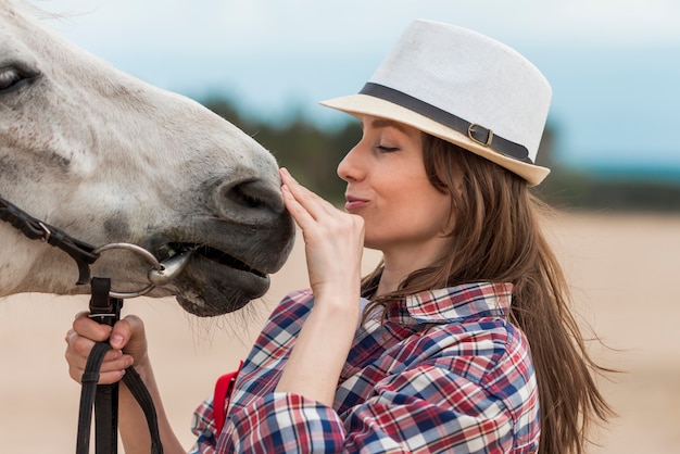 Mujer paseando con un caballo por la playa