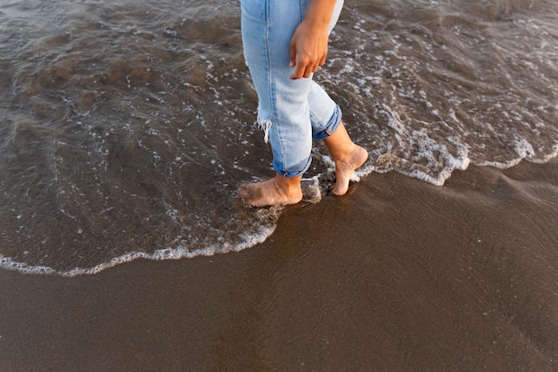 Mujer paseando por la playa en el agua