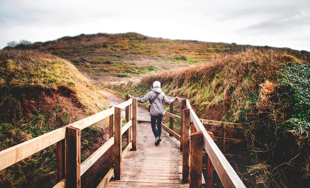 Mujer en un paseo marítimo de madera en la naturaleza