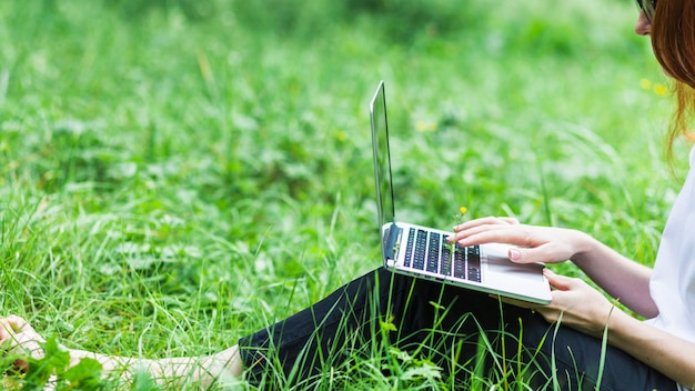 Mujer, en, pasto o césped, con, computador portatil