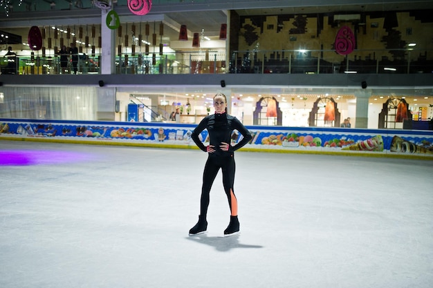 Mujer patinadora artística en la pista de patinaje sobre hielo