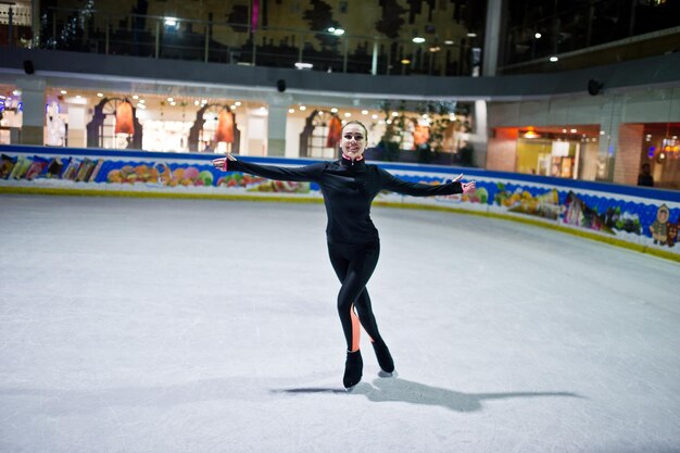 Mujer patinadora artística en la pista de patinaje sobre hielo