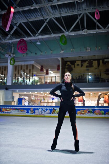 Mujer patinadora artística en la pista de patinaje sobre hielo