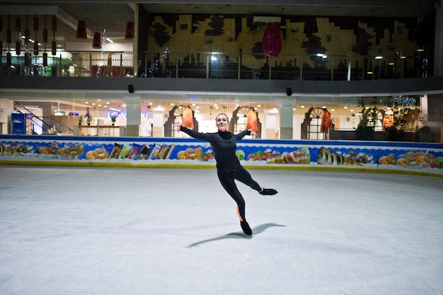 Mujer patinadora artística en la pista de patinaje sobre hielo