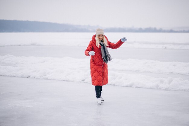Mujer patinando sobre hielo en el lago