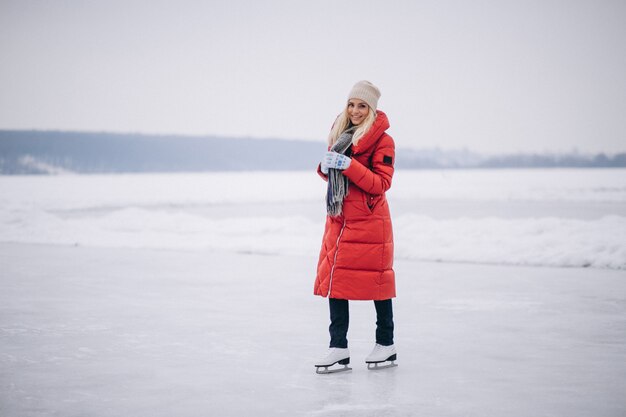 Mujer patinando sobre hielo en el lago