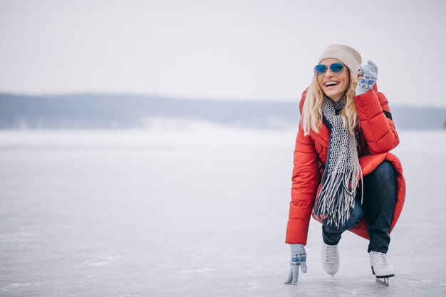 Mujer patinando sobre hielo en el lago