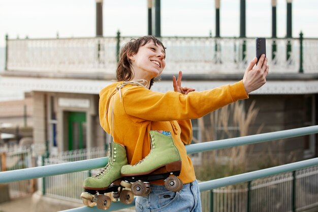 Mujer con patines tomando un selfie usando su teléfono inteligente al aire libre