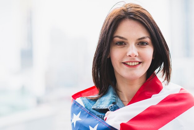 Mujer patriota envuelta en bandera americana