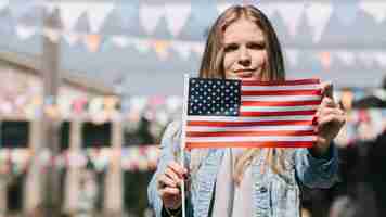 Foto gratuita mujer patriótica que muestra la bandera de estados unidos en el festival