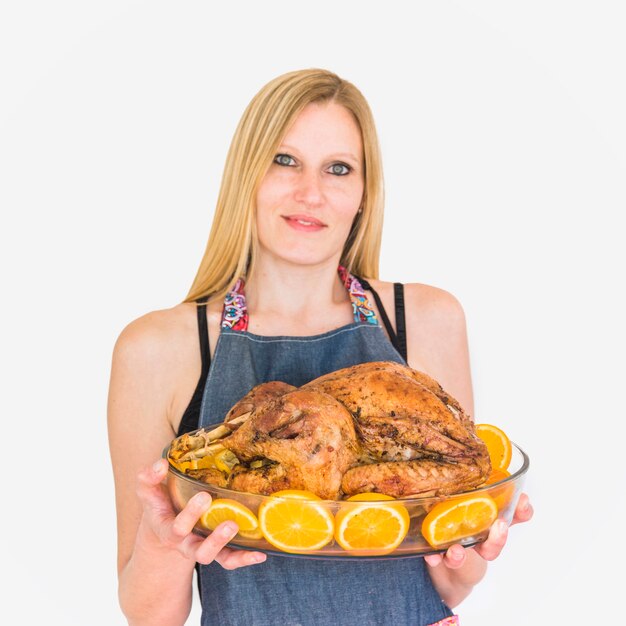 Mujer con pavo asado en cristalería.