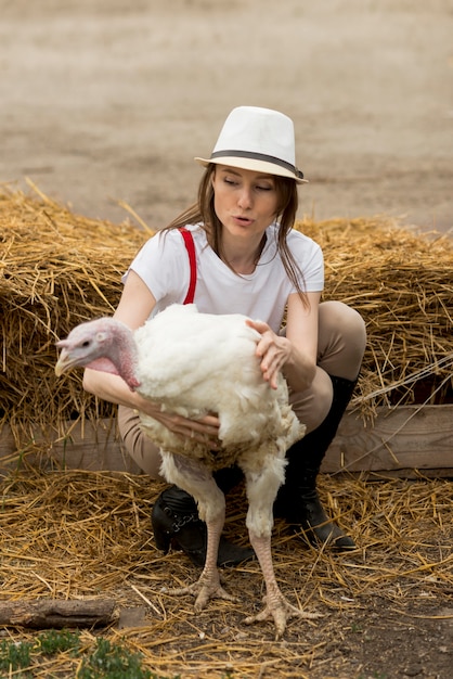 Foto gratuita mujer con un pavo en una granja