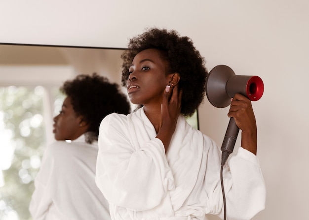 Foto gratuita mujer peinando cabello afro tiro medio