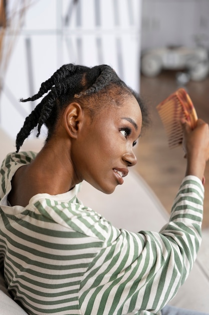 Foto gratuita mujer peinando el cabello con peine vista lateral
