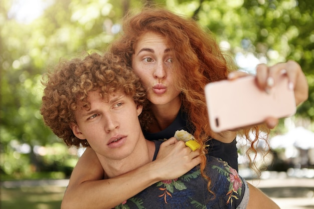 mujer pelirroja abrazando a su guapo novio