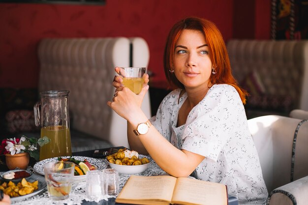 Mujer pelirroja almorzando en el restaurante