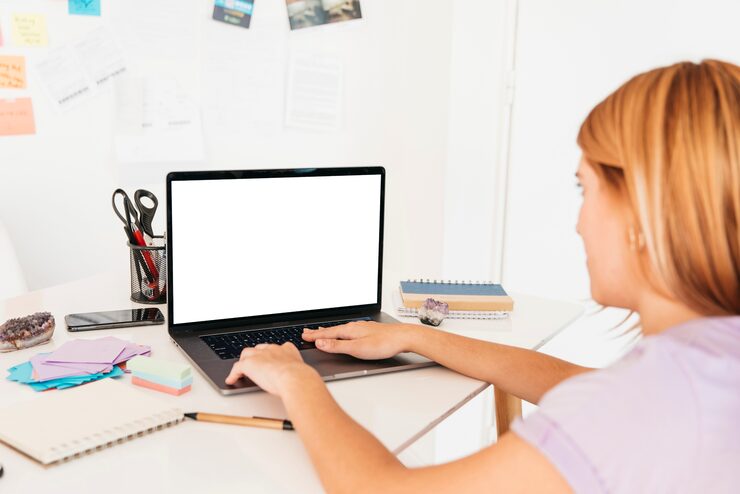 Foto gratuito mujer pelirroja escribiendo en la computadora portátil en el escritorio con papelería