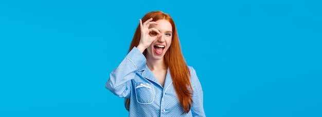 Mujer pelirroja feliz despreocupada y atrevida con ojos azules que muestra bien, sin preocupaciones y gesto de satisfacción