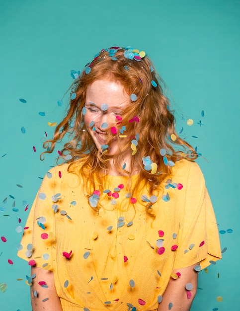 Mujer pelirroja feliz de fiesta con confeti en el pelo