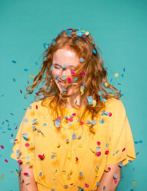 Mujer pelirroja feliz de fiesta con confeti en el pelo