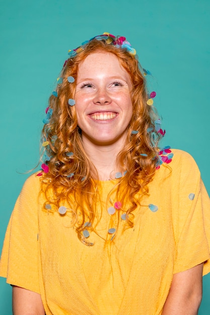 Mujer pelirroja de fiesta con confeti en el pelo
