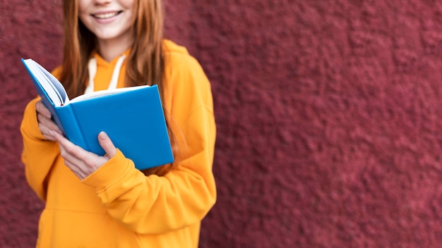 Mujer pelirroja leyendo un libro con espacio de copia