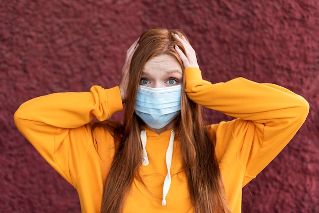 Foto gratuita mujer pelirroja con una mascarilla