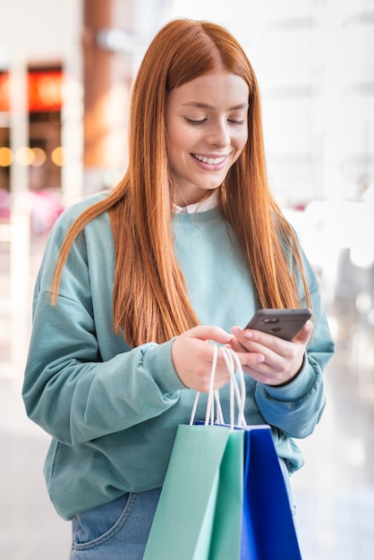 Mujer pelirroja mirando por teléfono