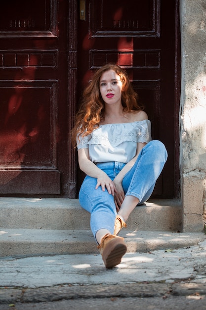 Mujer pelirroja posando delante de una puerta