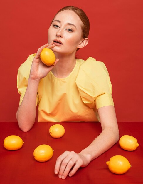 Mujer pelirroja posando con limones