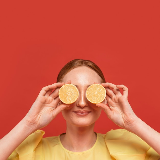 Mujer pelirroja posando con limones