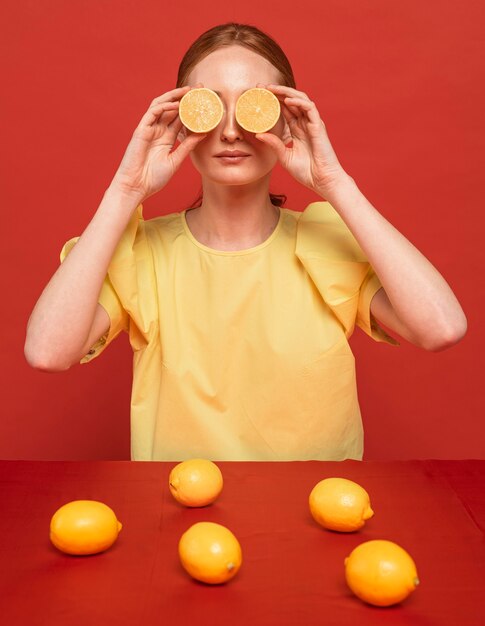 Mujer pelirroja posando con limones