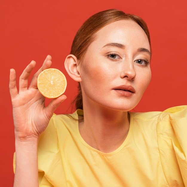 Mujer pelirroja posando con limones