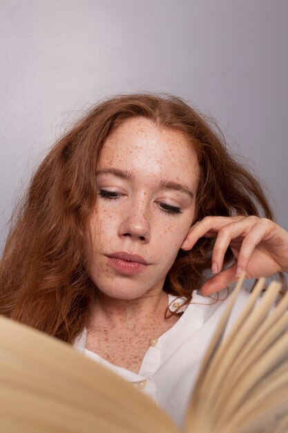 Mujer pelirroja de primer plano leyendo