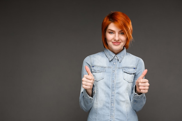 Mujer pelirroja satisfecha pulgar hacia arriba