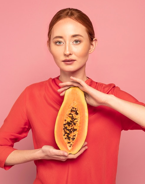 Mujer pelirroja sosteniendo un melón