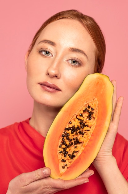 Mujer pelirroja sosteniendo un melón