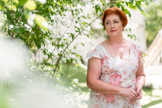 Mujer pelirroja en vestido floral mirando lejos