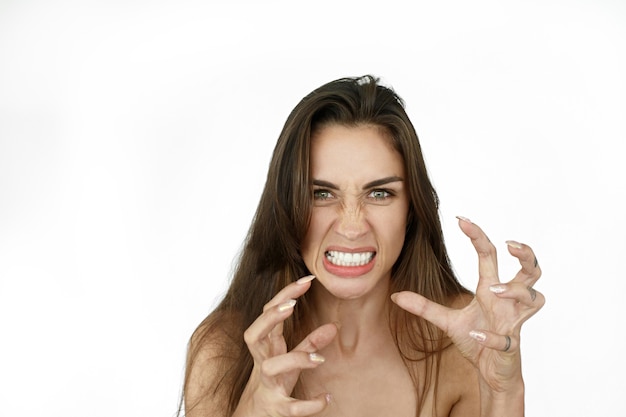 La mujer con el pelo largo parece de miedo pie sobre fondo blanco