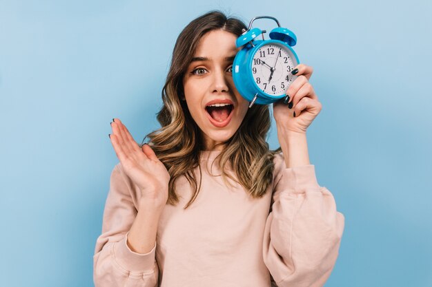 Mujer, con, pelo ondulado, tenencia, reloj