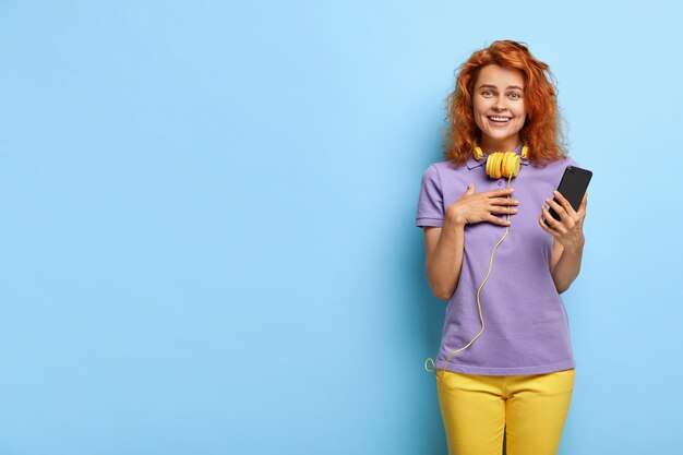 Mujer de pelo rojo rizado toca leer un mensaje atrevido, se siente conmovida e impresionada